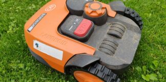 Robotfűnyírók és okos öntözőrendszerek: így automatizáld a kertgondozást, hogy több időd maradjon a pihenésre Robotfűnyíró friss zöld gyepen egy vidéki kertben